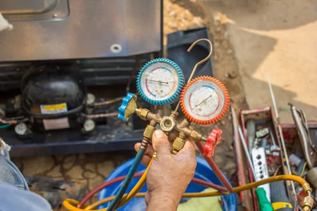 HVAC technician testing an AC capacitor in a Slidell, LA home